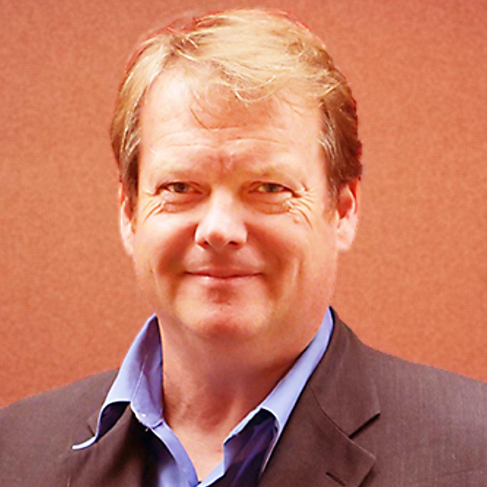 Portrait of Steinn Sigurðsson in a grey jacket and blue shirt against a warm orange background.